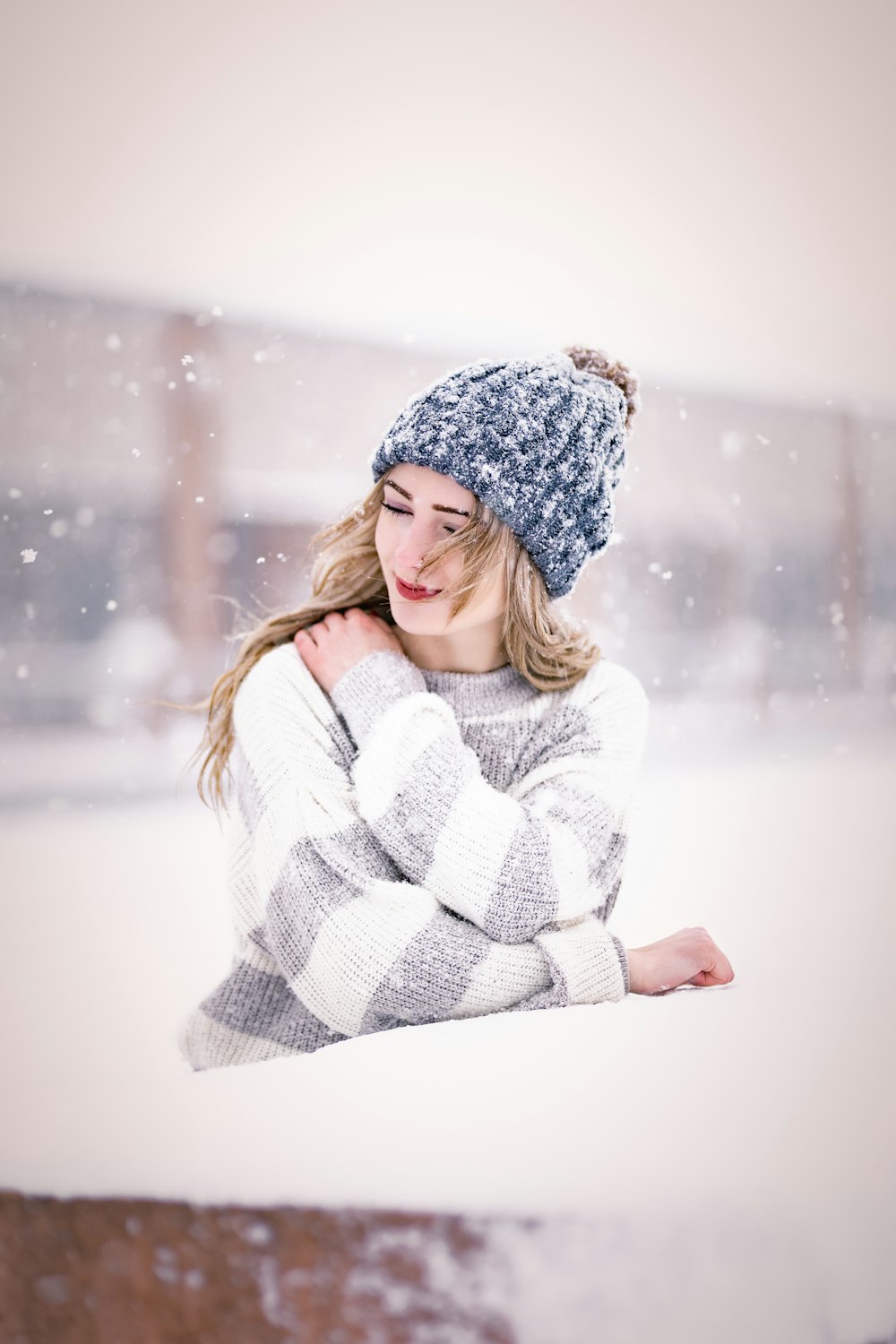 a woman wearing a hat and sweater in the snow