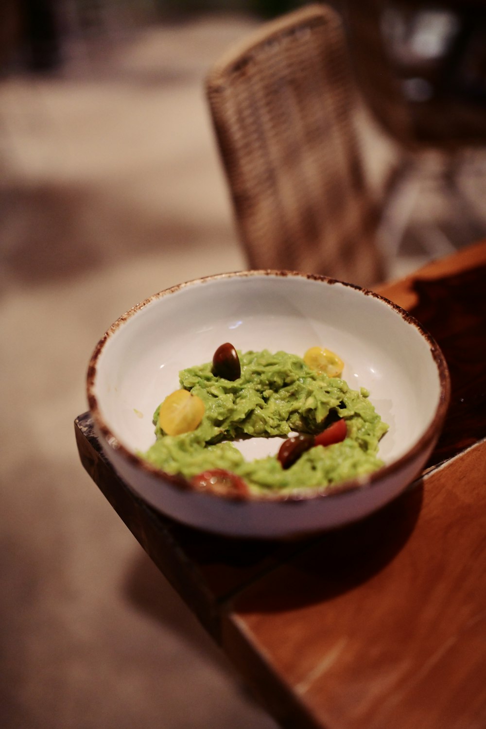 a bowl of guacamole on a wooden table