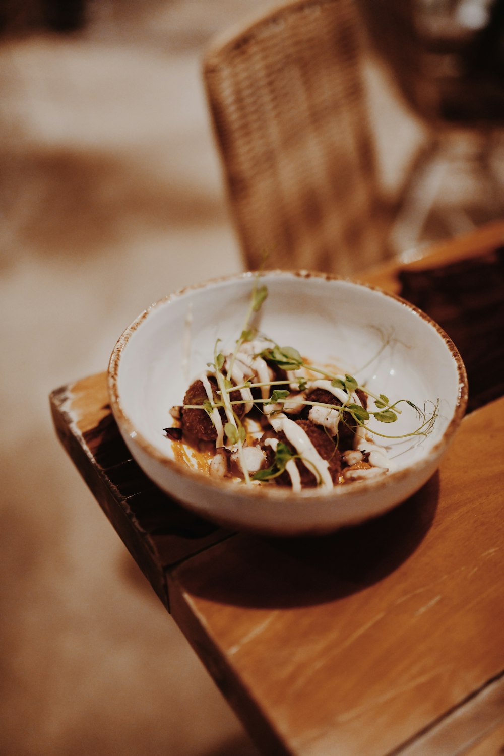 a bowl of food sitting on top of a wooden table