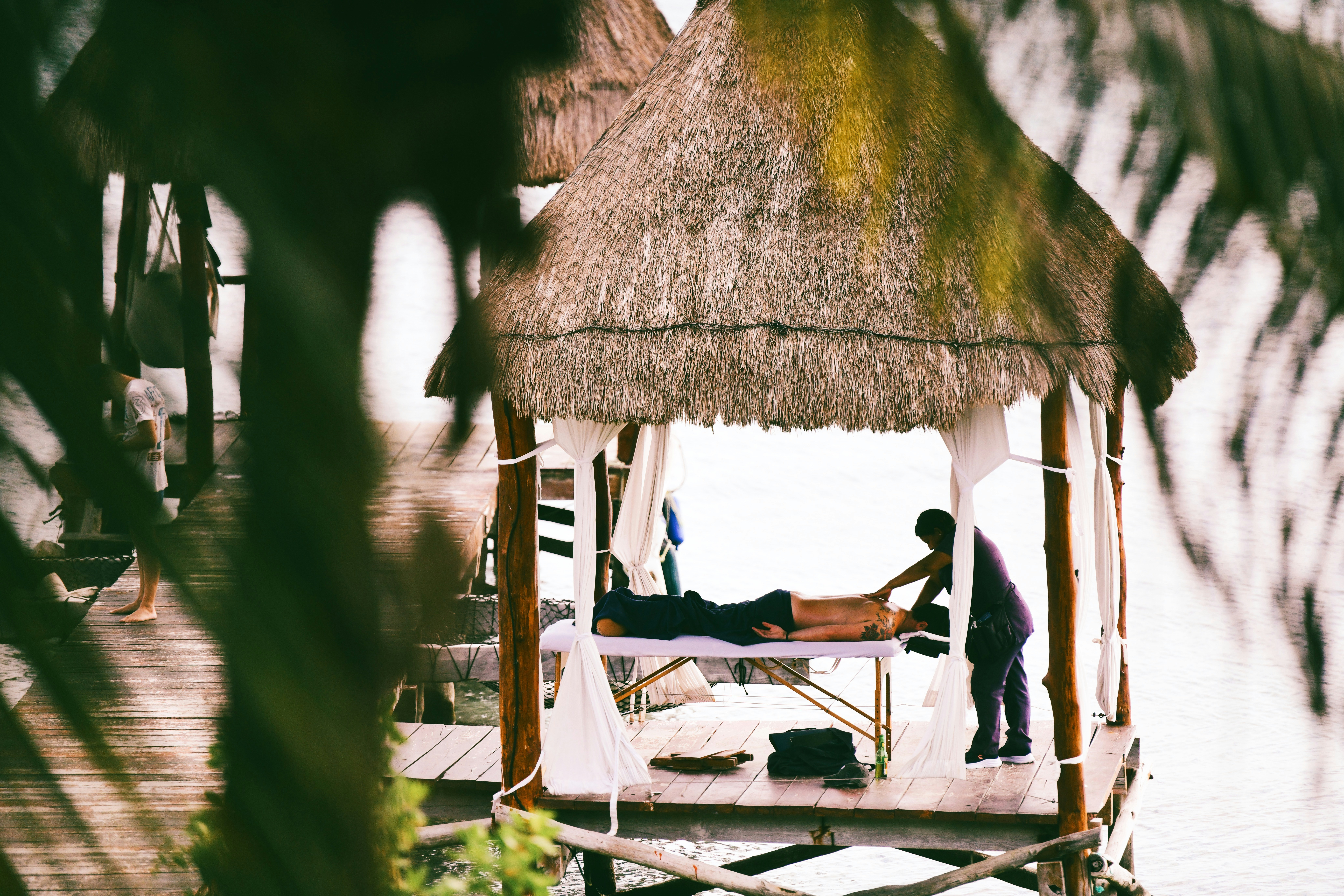 a man laying on a bed in a hut