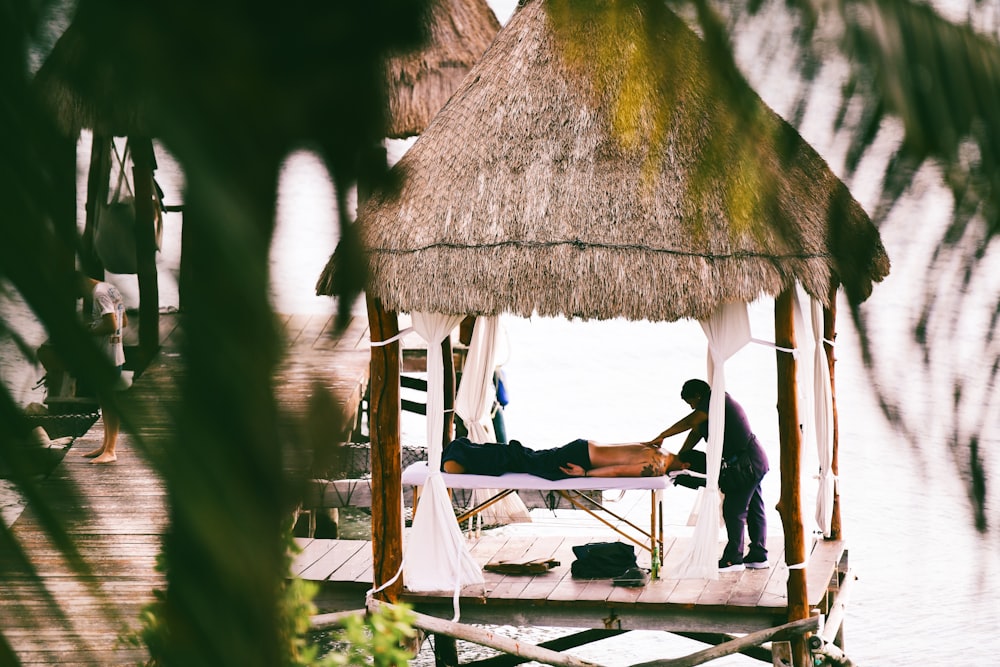 a man laying on a bed in a hut