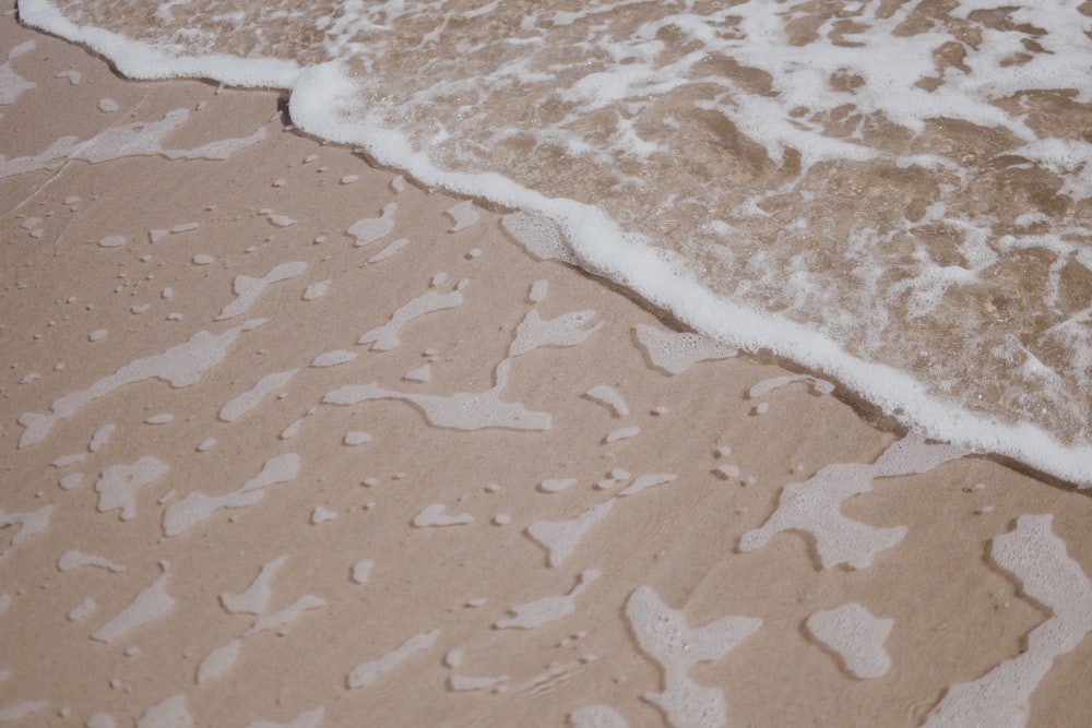 un gros plan d’eau et de sable sur une plage