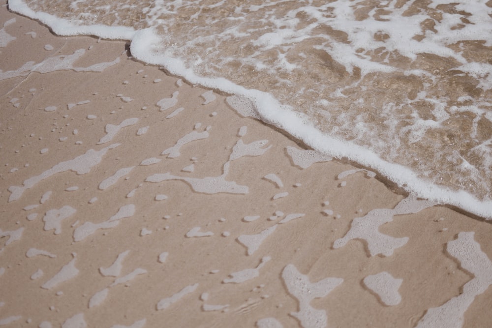 a close up of water and sand on a beach