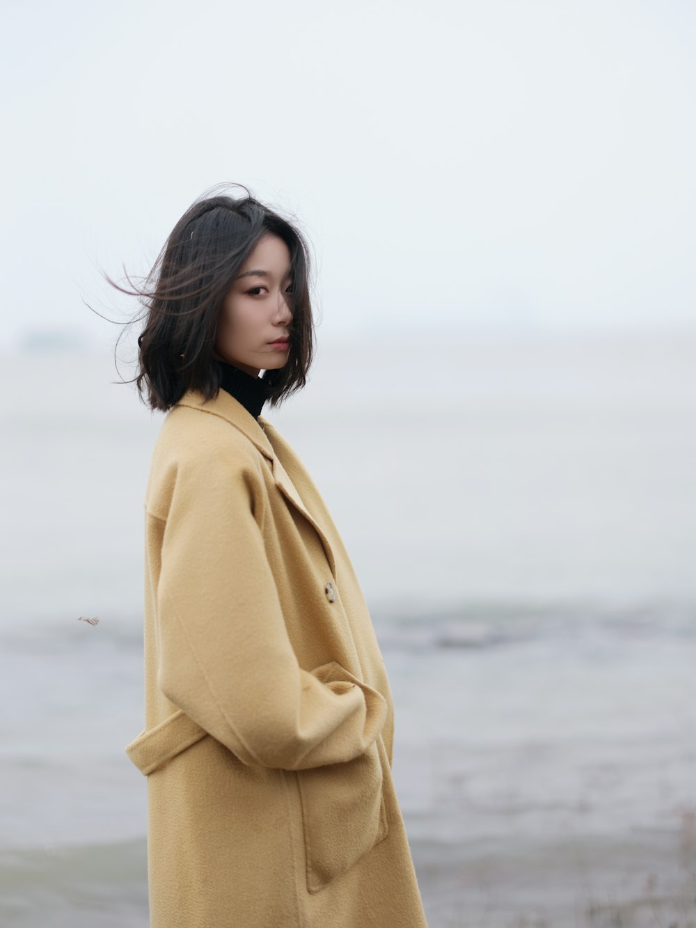 a woman standing in front of a body of water