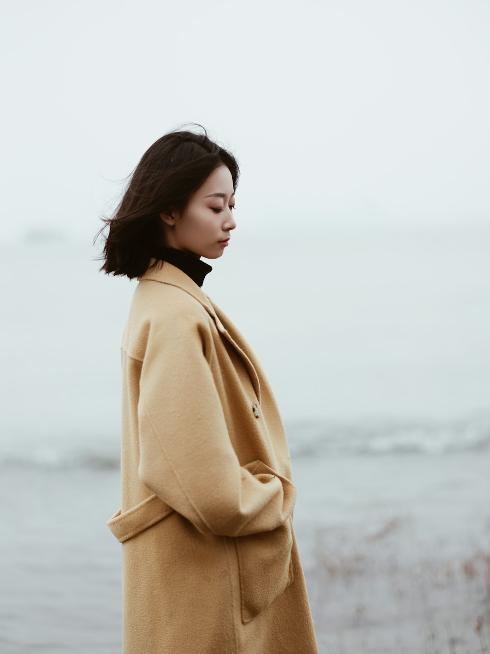 a woman standing in front of a body of water