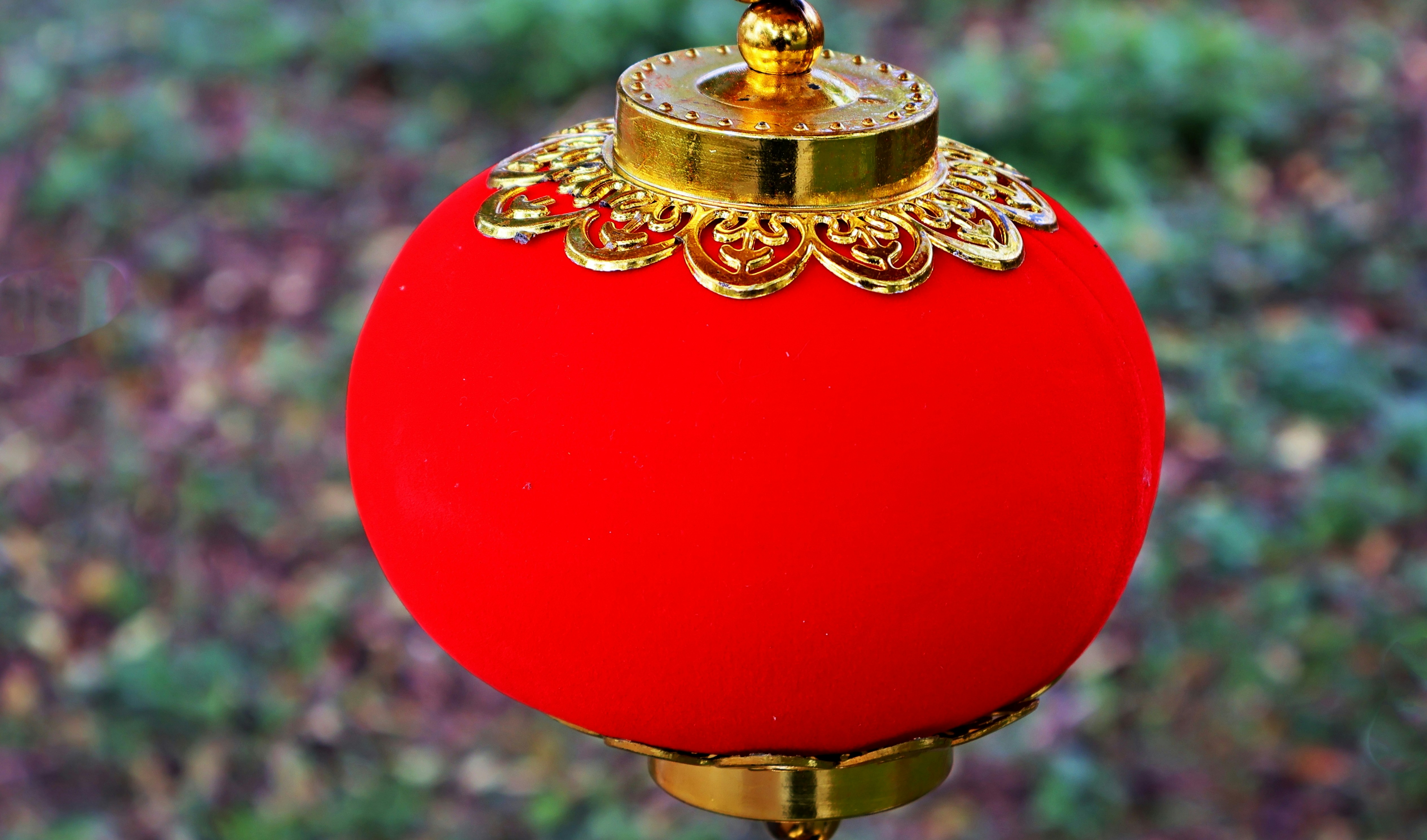 a red ball with a gold decoration on top of it