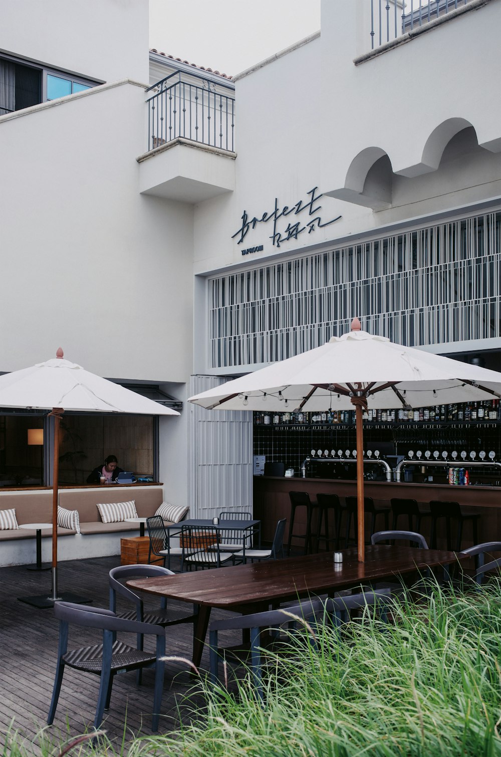 a restaurant with tables and umbrellas outside of it