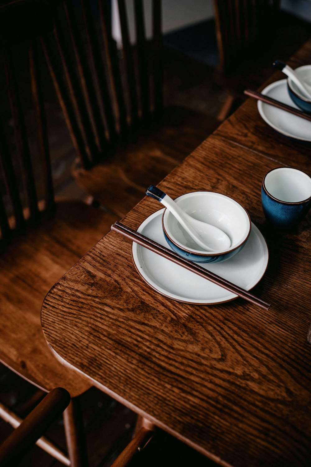 a wooden table topped with plates and bowls