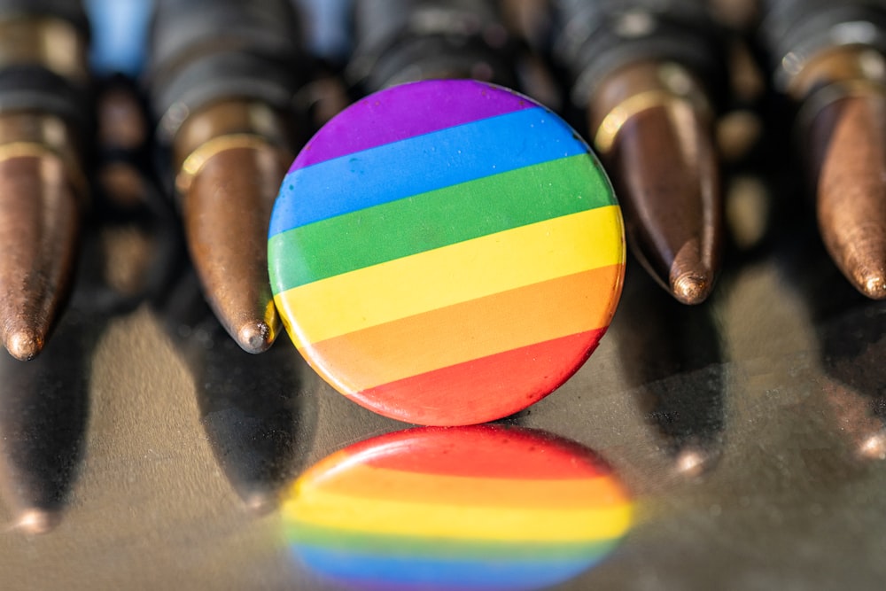 um botão colorido do arco-íris sentado em cima de uma mesa