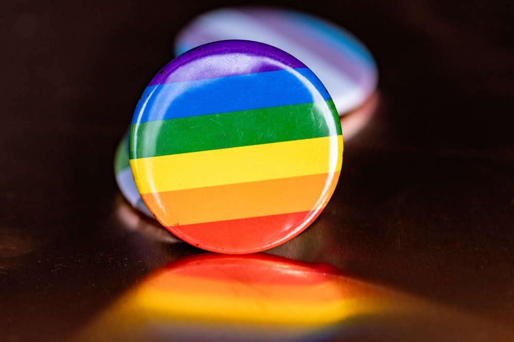 um botão colorido do arco-íris sentado em cima de uma mesa