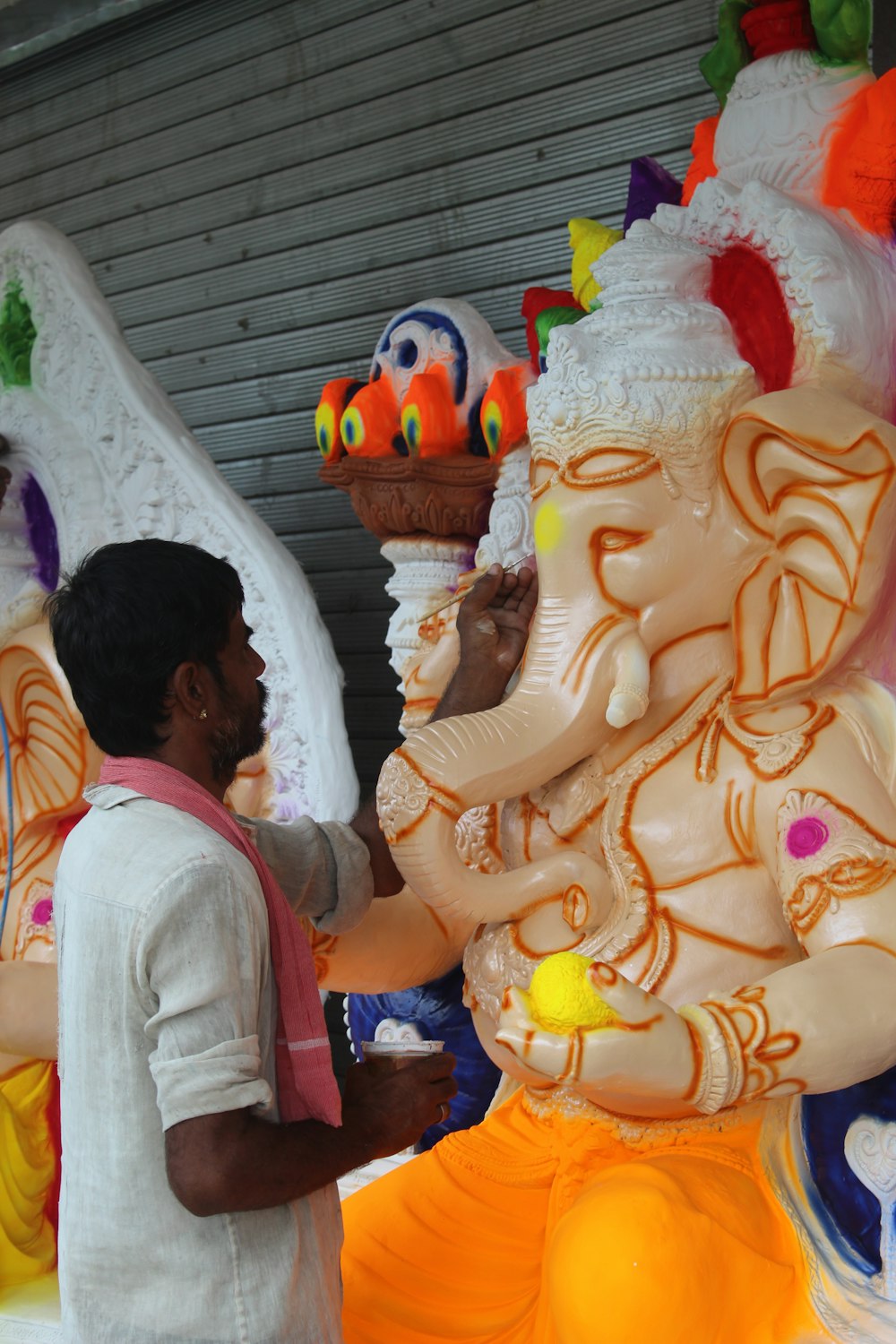 a man standing next to a statue of an elephant