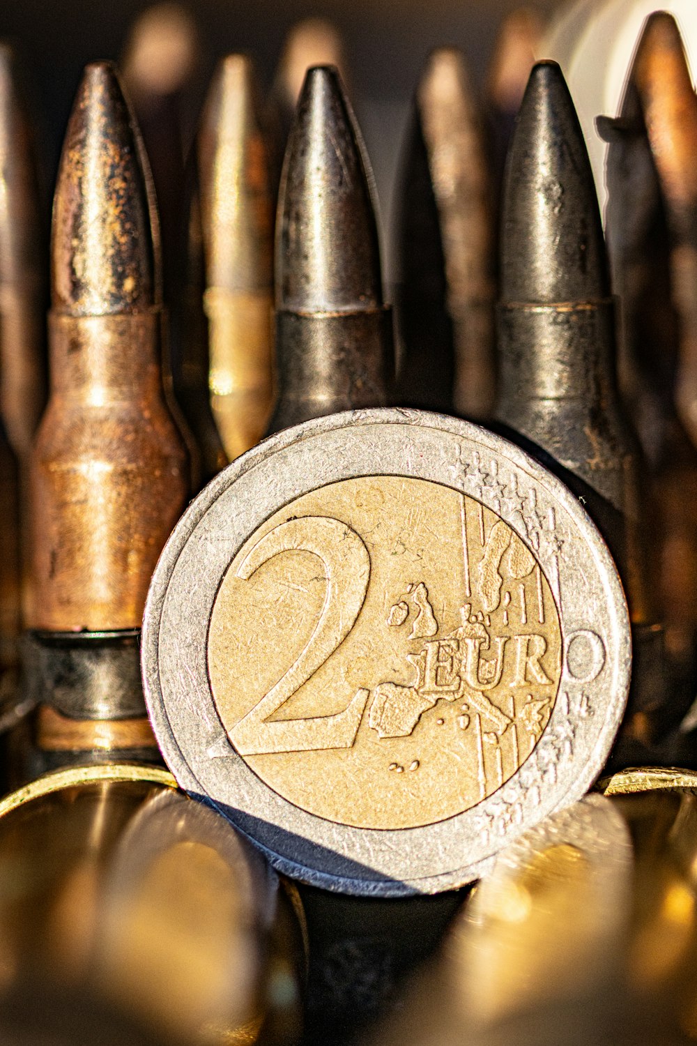 a two euro coin sitting on top of a pile of bullet casks