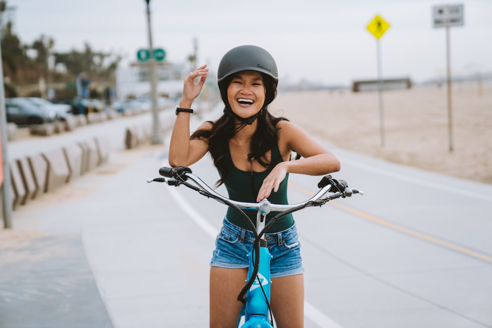 a woman in a helmet is riding a bike