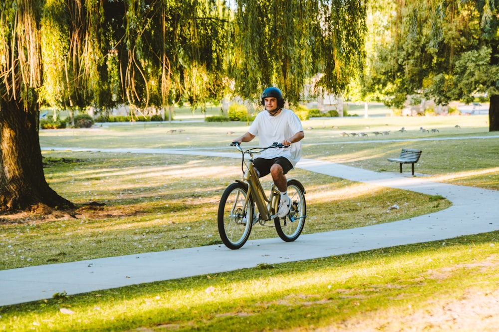 a man riding a bike through a park