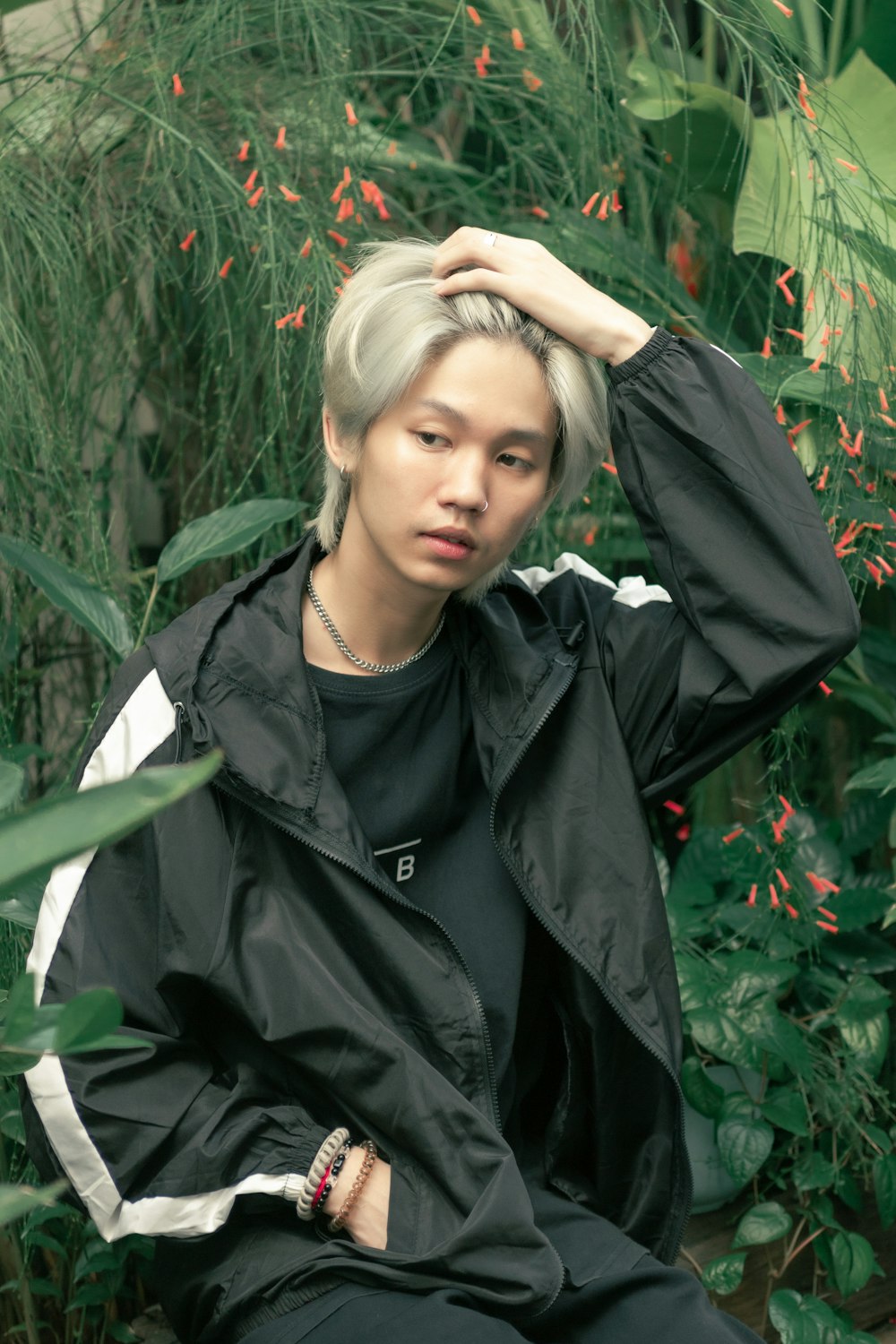 a young man with grey hair sitting on a bench