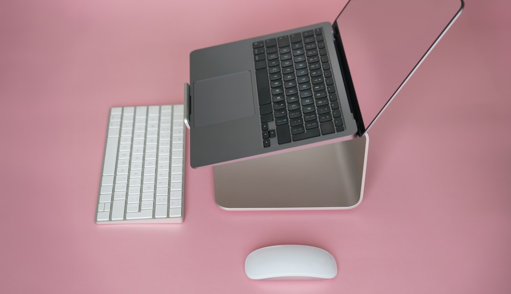 a laptop computer sitting on top of a desk next to a mouse