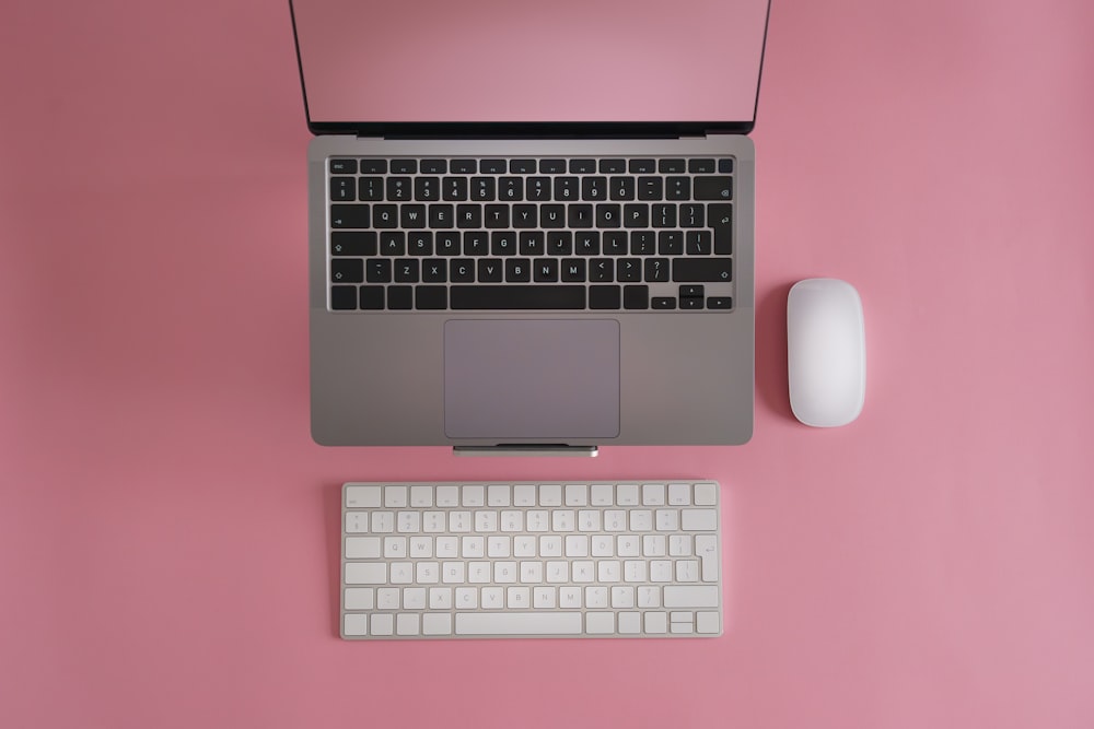분홍색 책상 위에 놓인 노트북 컴퓨터