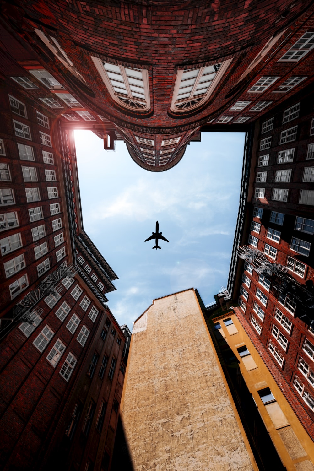 an airplane flying over a tall building in the sky