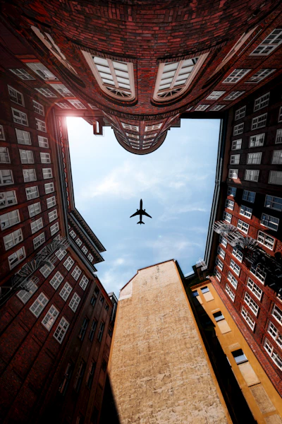 an airplane flying over a tall building in the sky