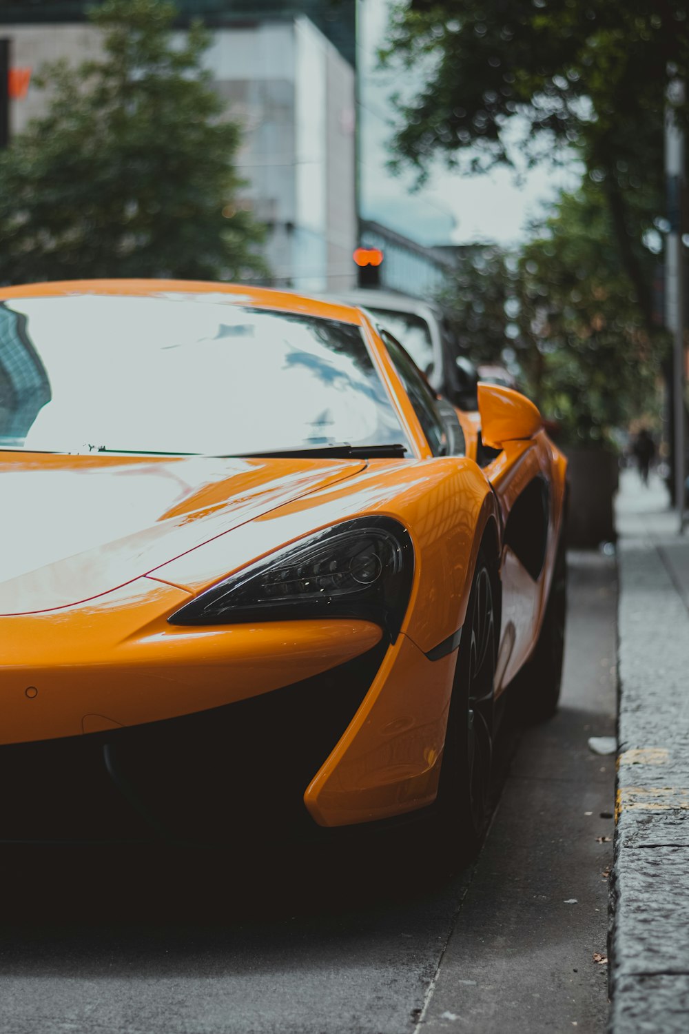 a yellow sports car parked on the side of the road