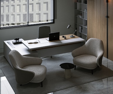 a desk with a chair and a laptop on it