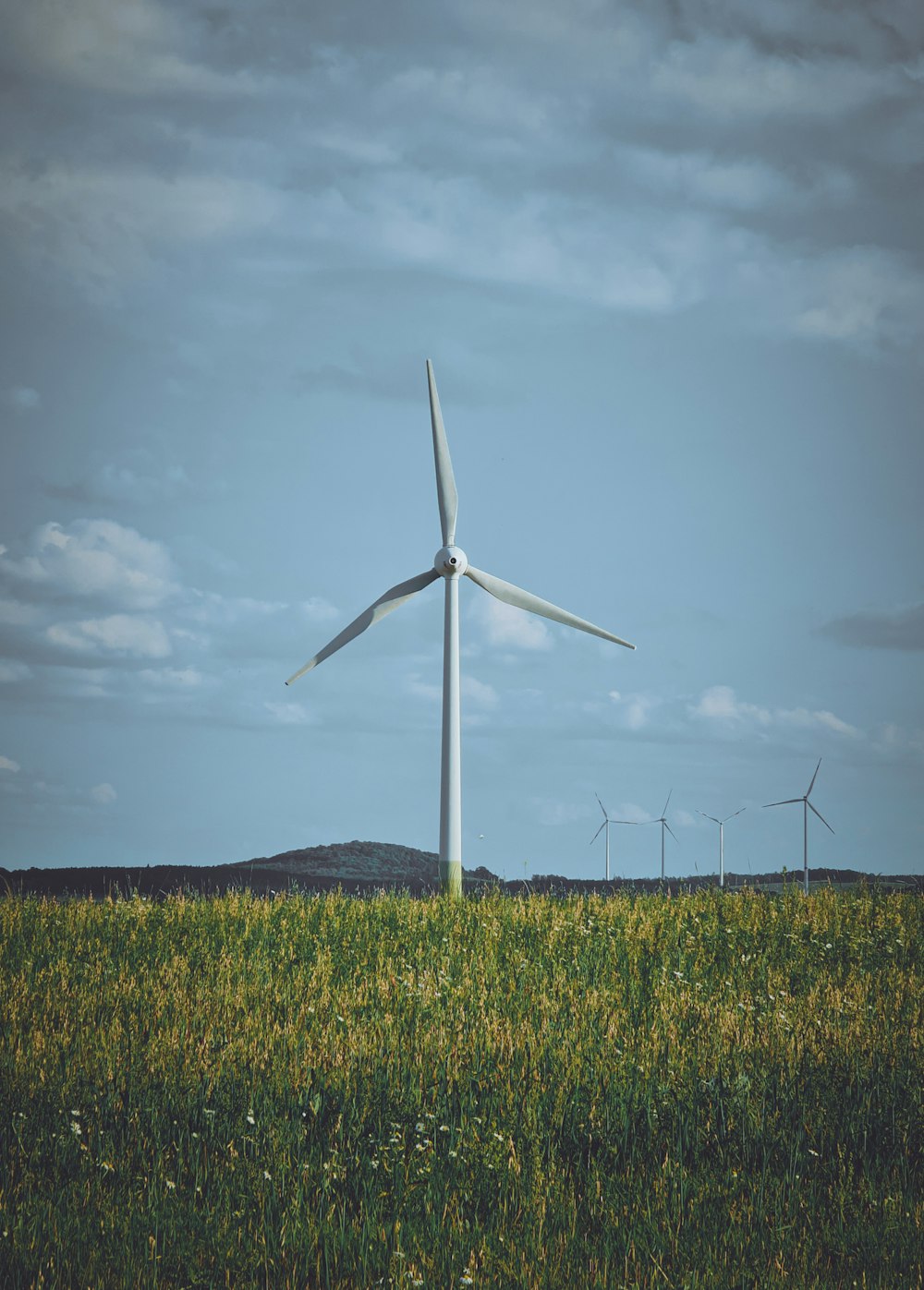 eine Windkraftanlage auf einem Feld mit grünem Gras