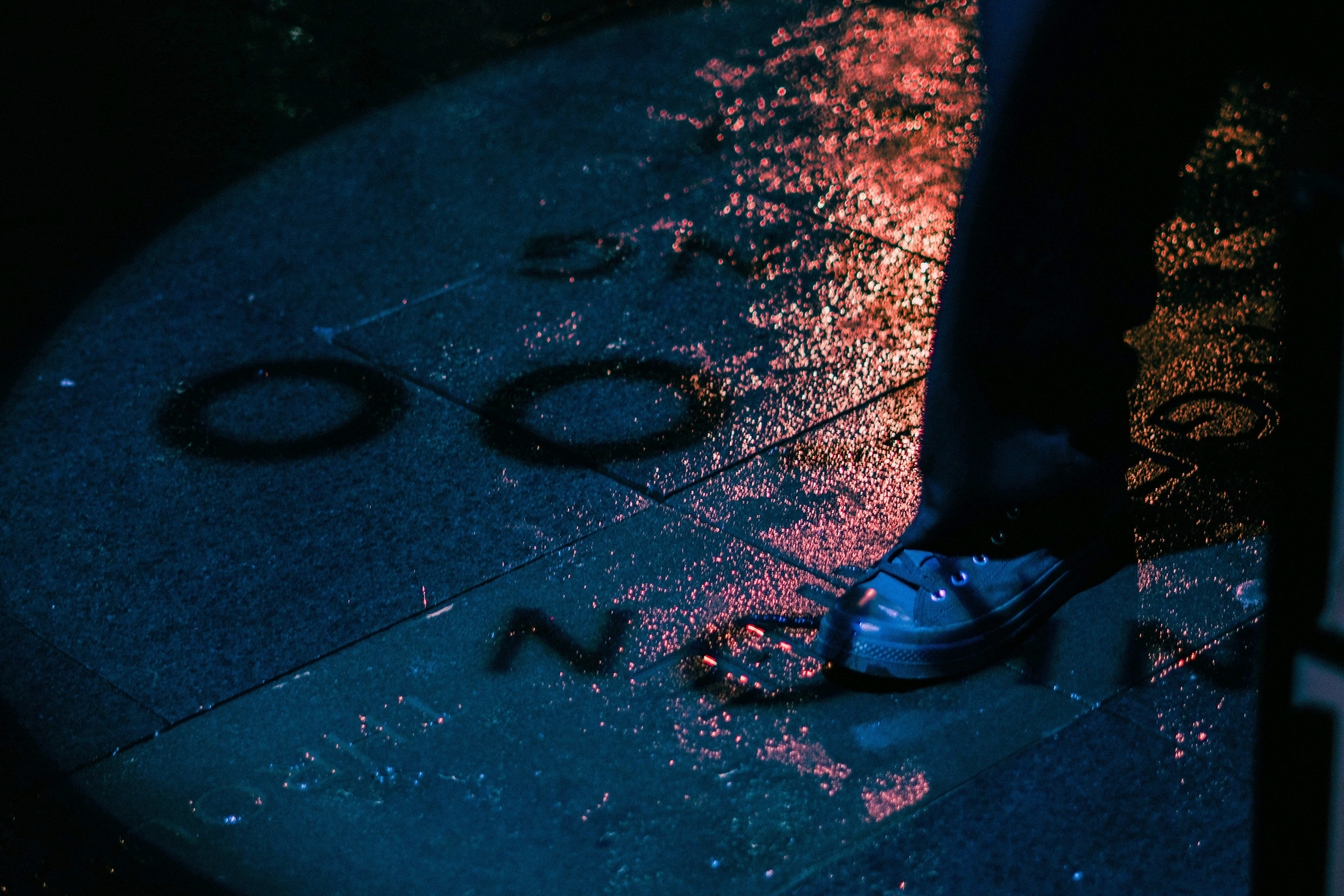 a person standing on a sidewalk in the rain