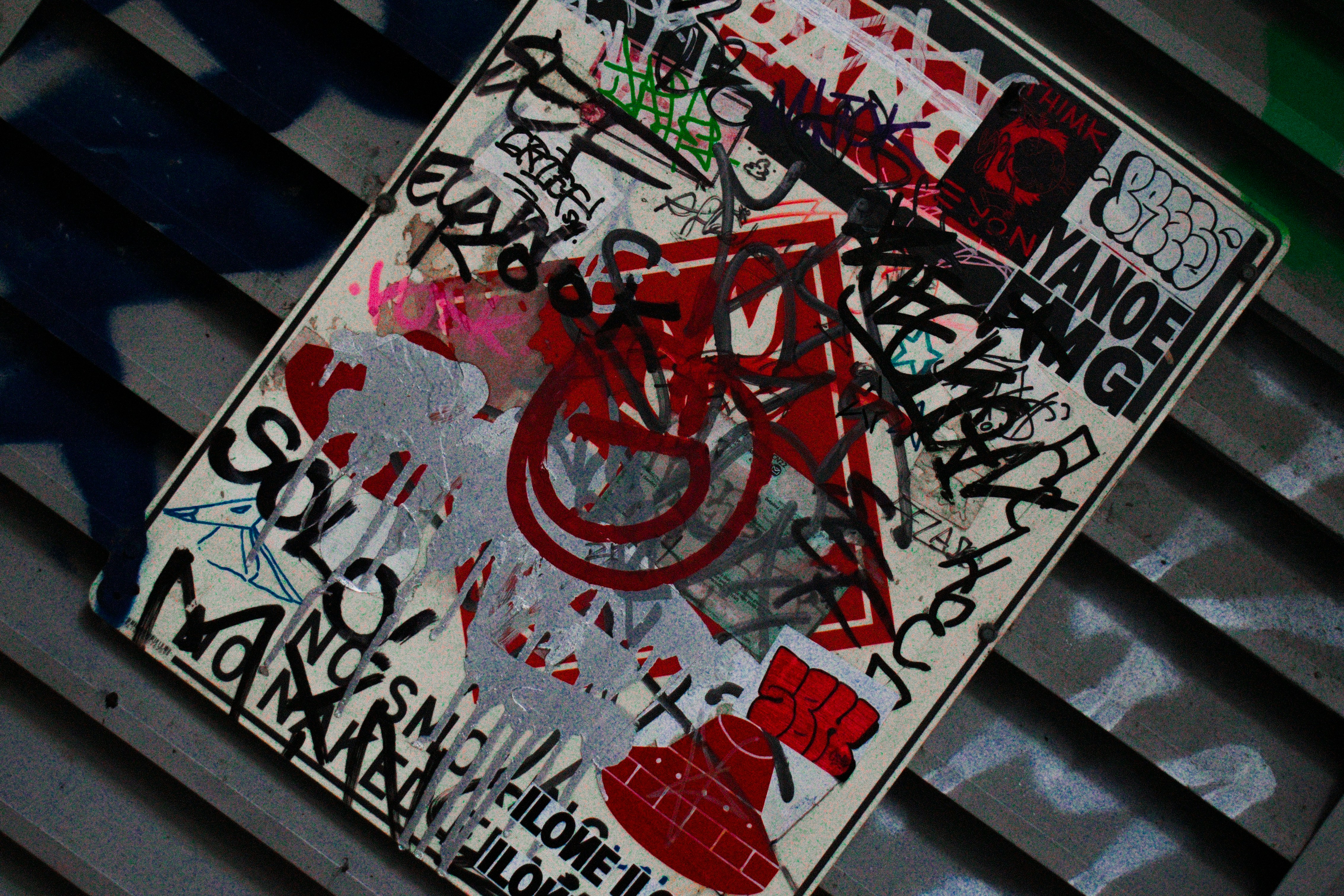 a street sign covered in graffiti on the side of a building