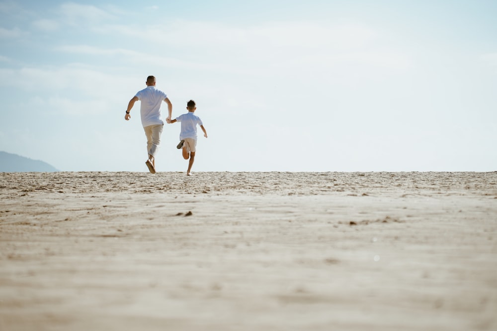 Ein Mann und eine Frau rennen über einen Sandstrand