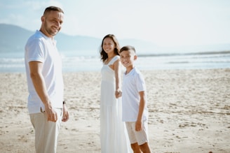 a man and two children standing on a beach