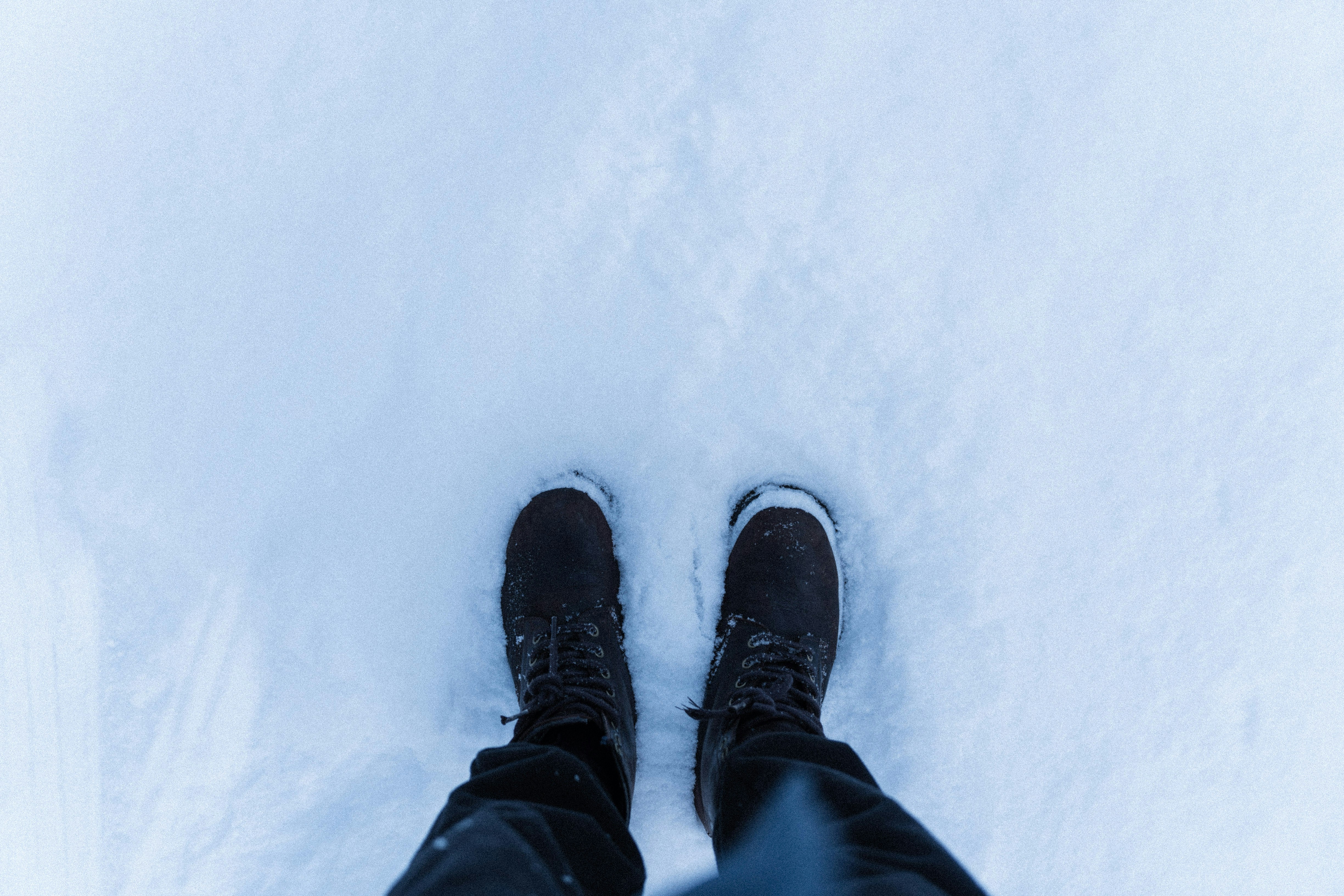 a person standing in the snow with their feet in the snow