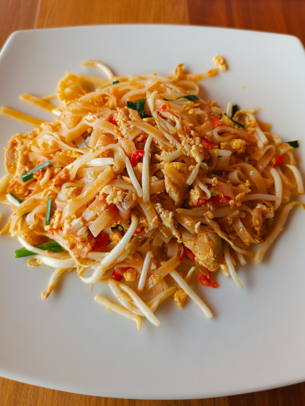 a white plate topped with noodles and vegetables