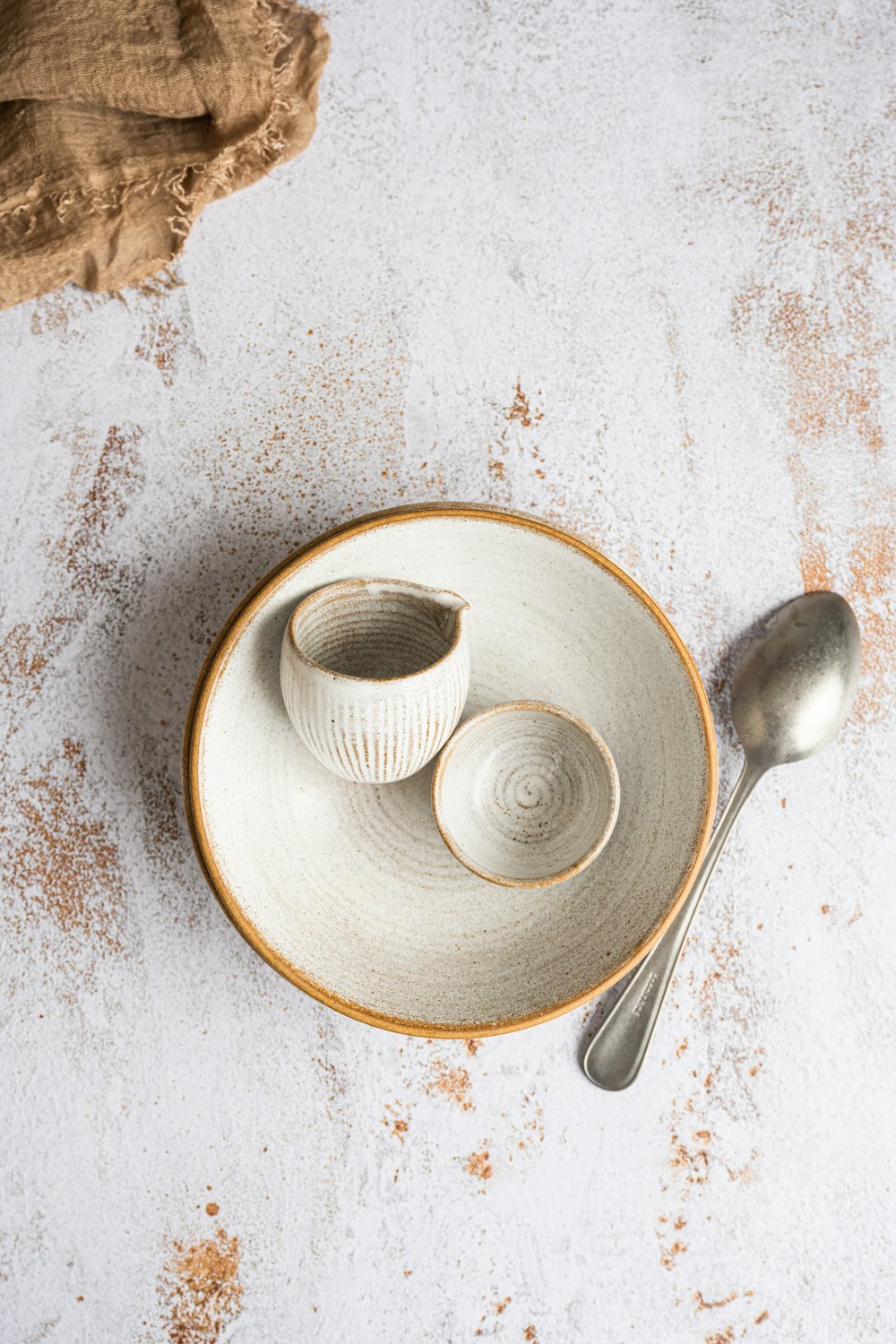 a white plate with two bowls and a spoon