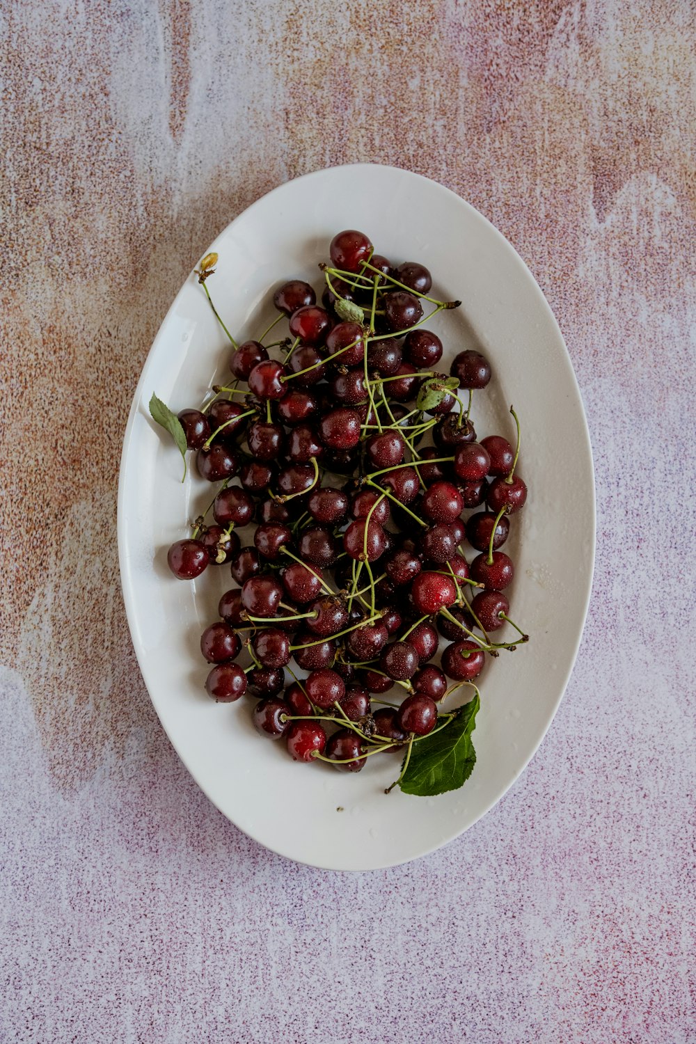 a white bowl filled with cherries on top of a table