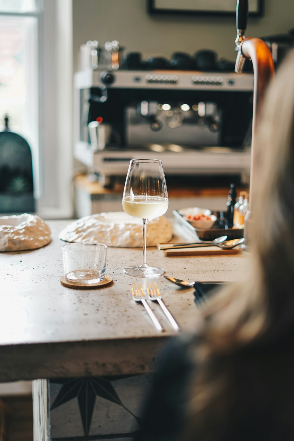 a woman sitting at a table with a glass of wine