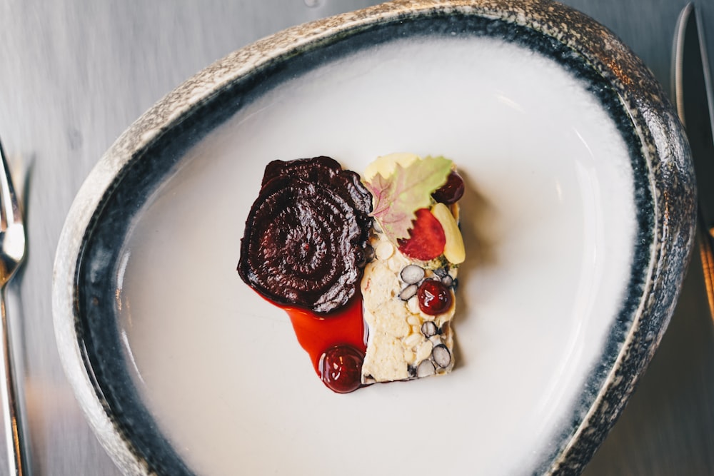 a white plate topped with a piece of cake and fruit