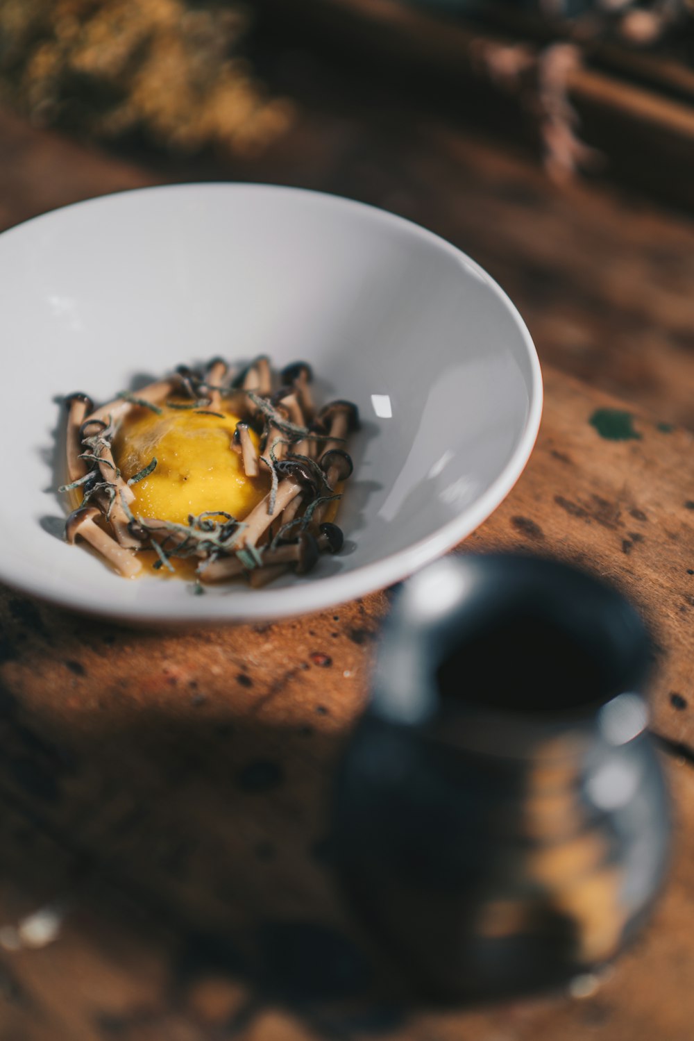 a white bowl filled with food on top of a wooden table