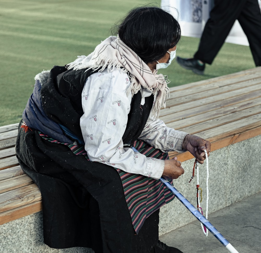 a person sitting on a bench with a cane