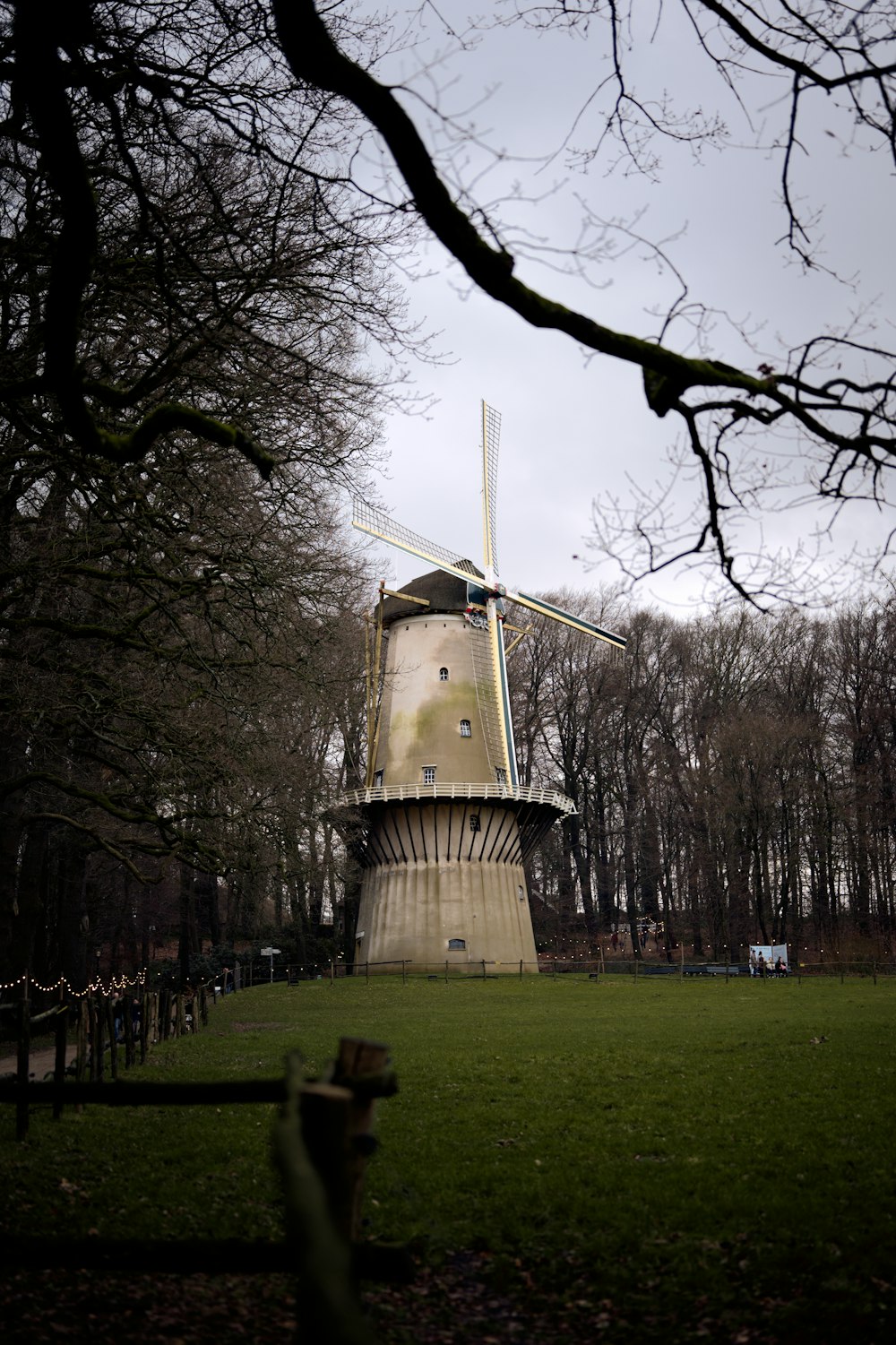 a windmill in the middle of a grassy field