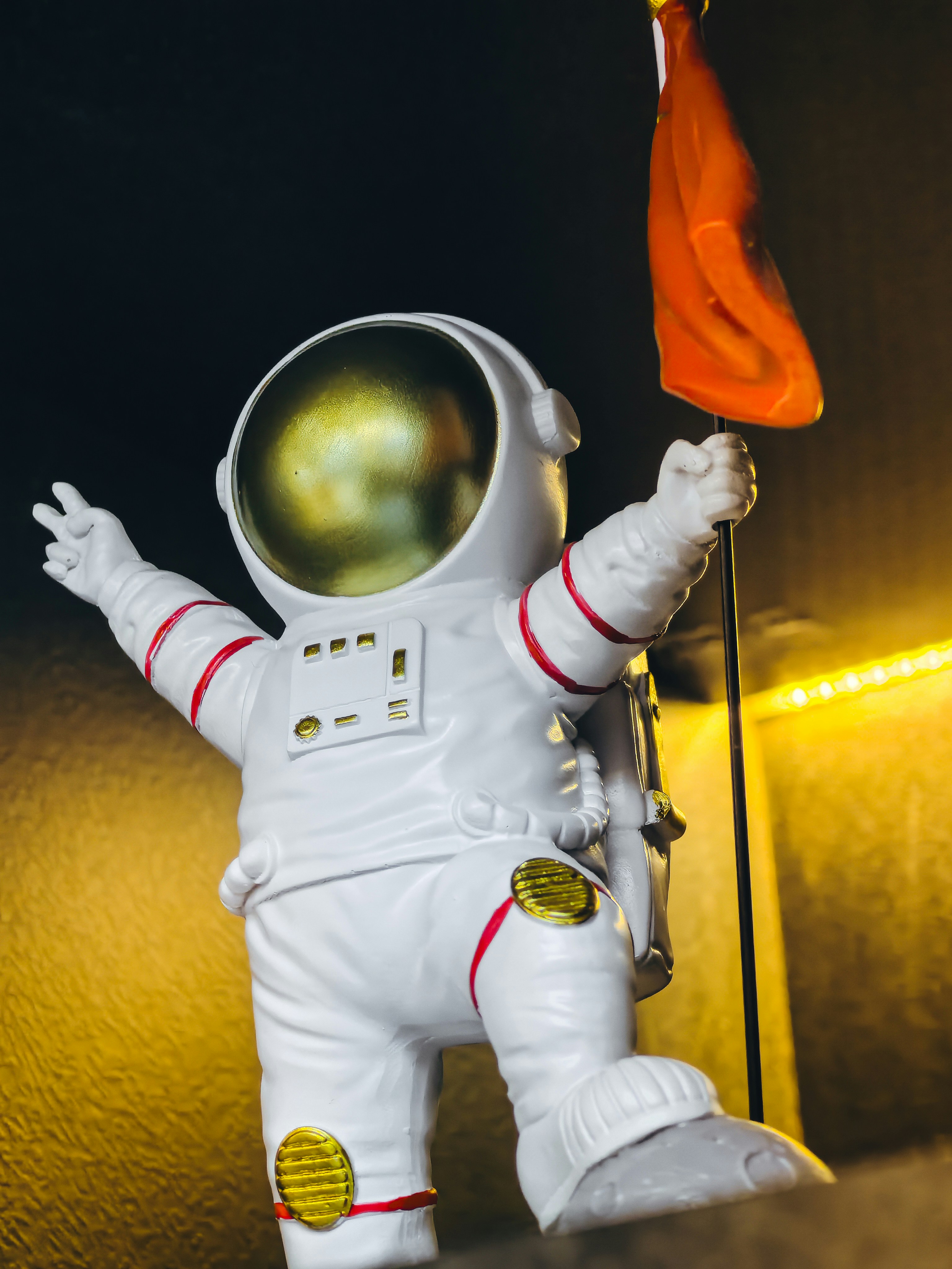 a toy astronaut holding an orange flag