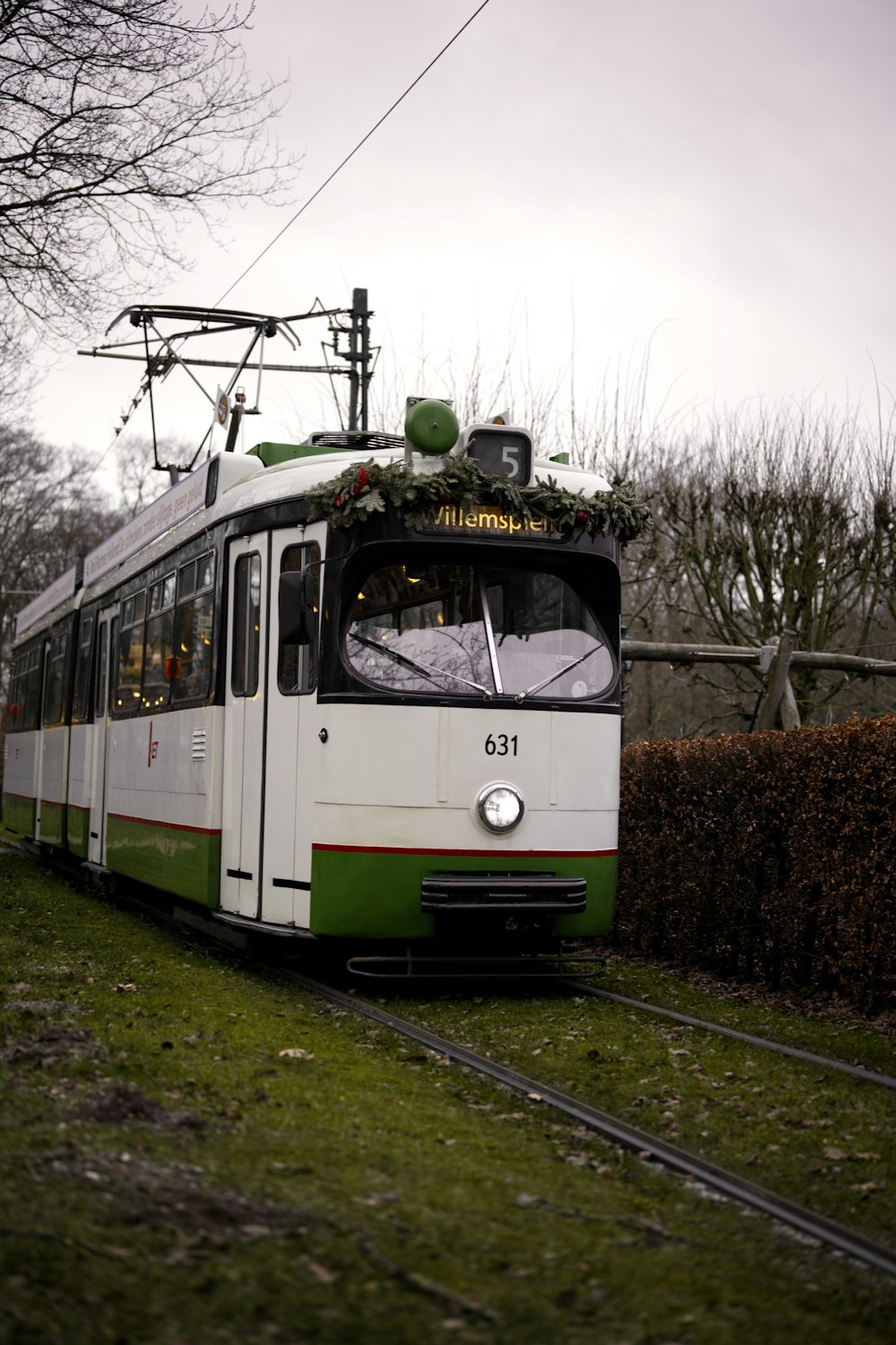 a green and white train traveling down train tracks