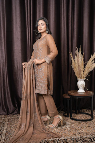 a woman standing in front of a brown curtain