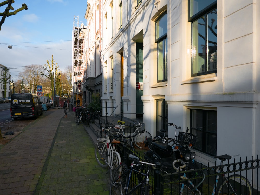 a row of bikes parked on the side of a building