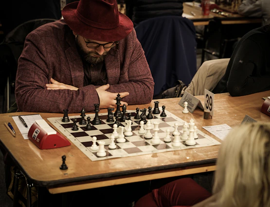 a man sitting at a table playing a game of chess