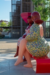 a couple of women sitting on top of a red ben at Niortch