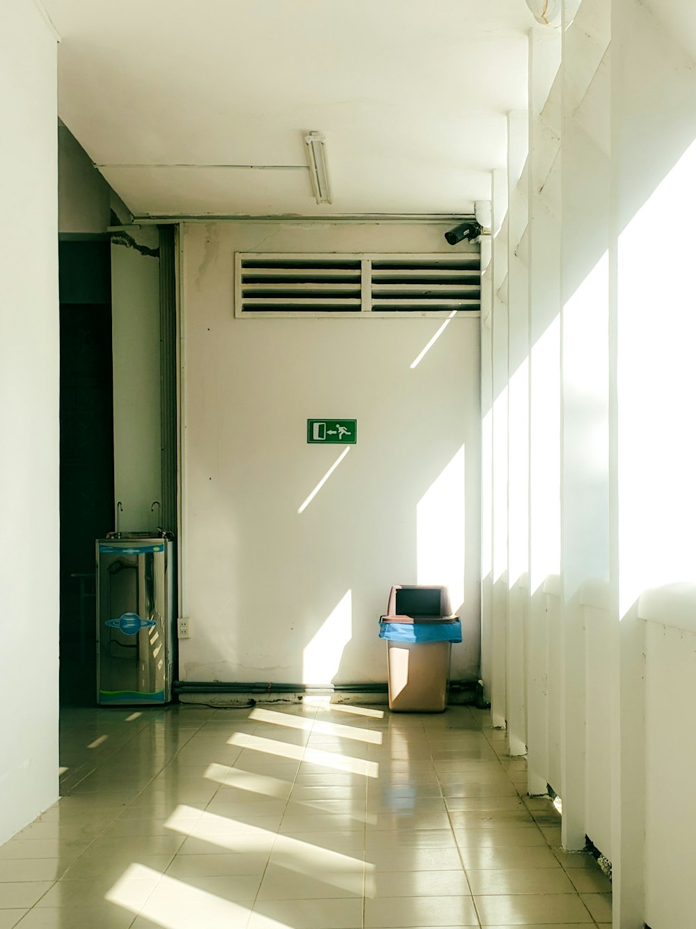 a hallway with a chair and a trash can