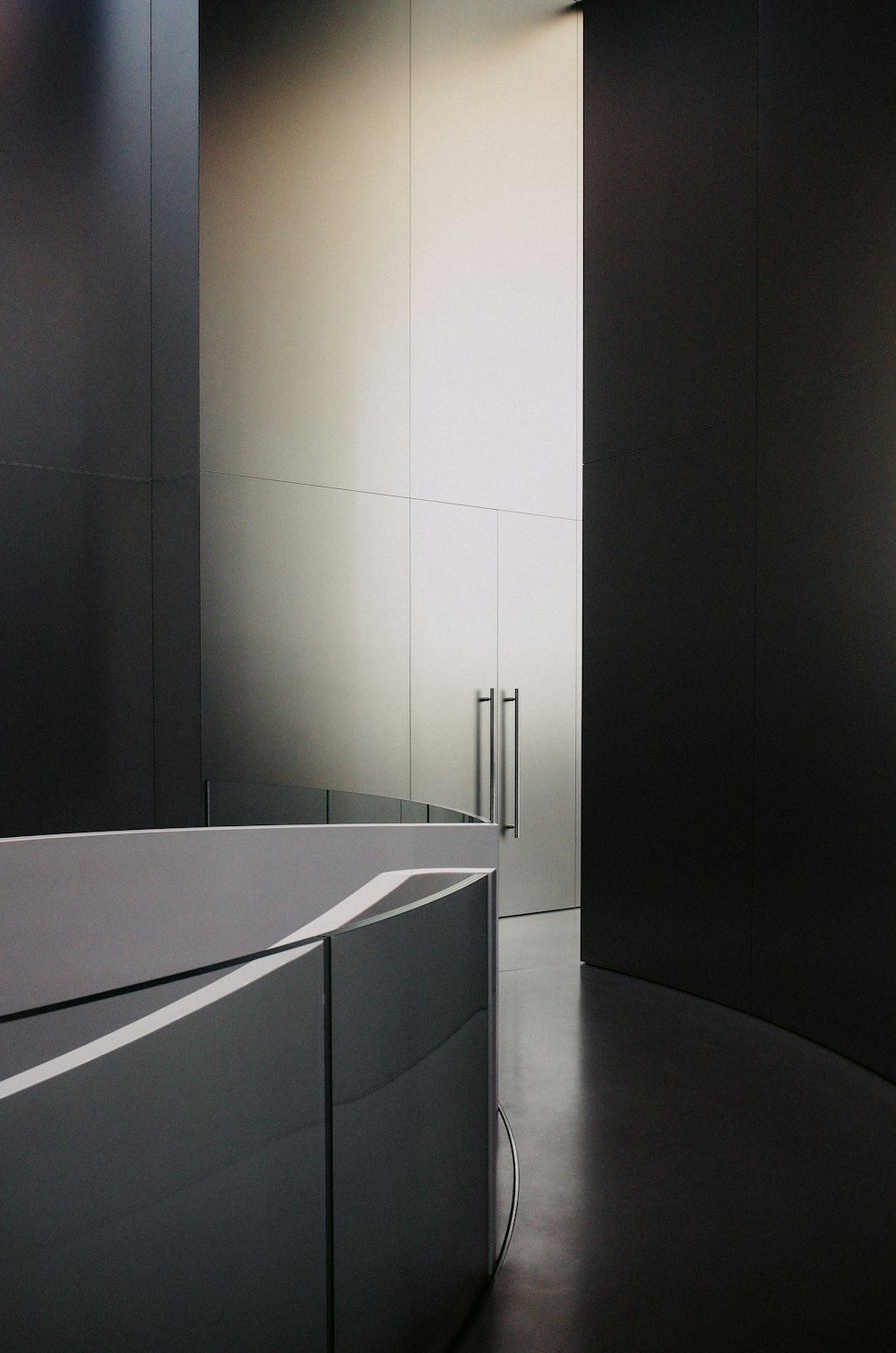 a bathroom with a curved bathtub and a mirror