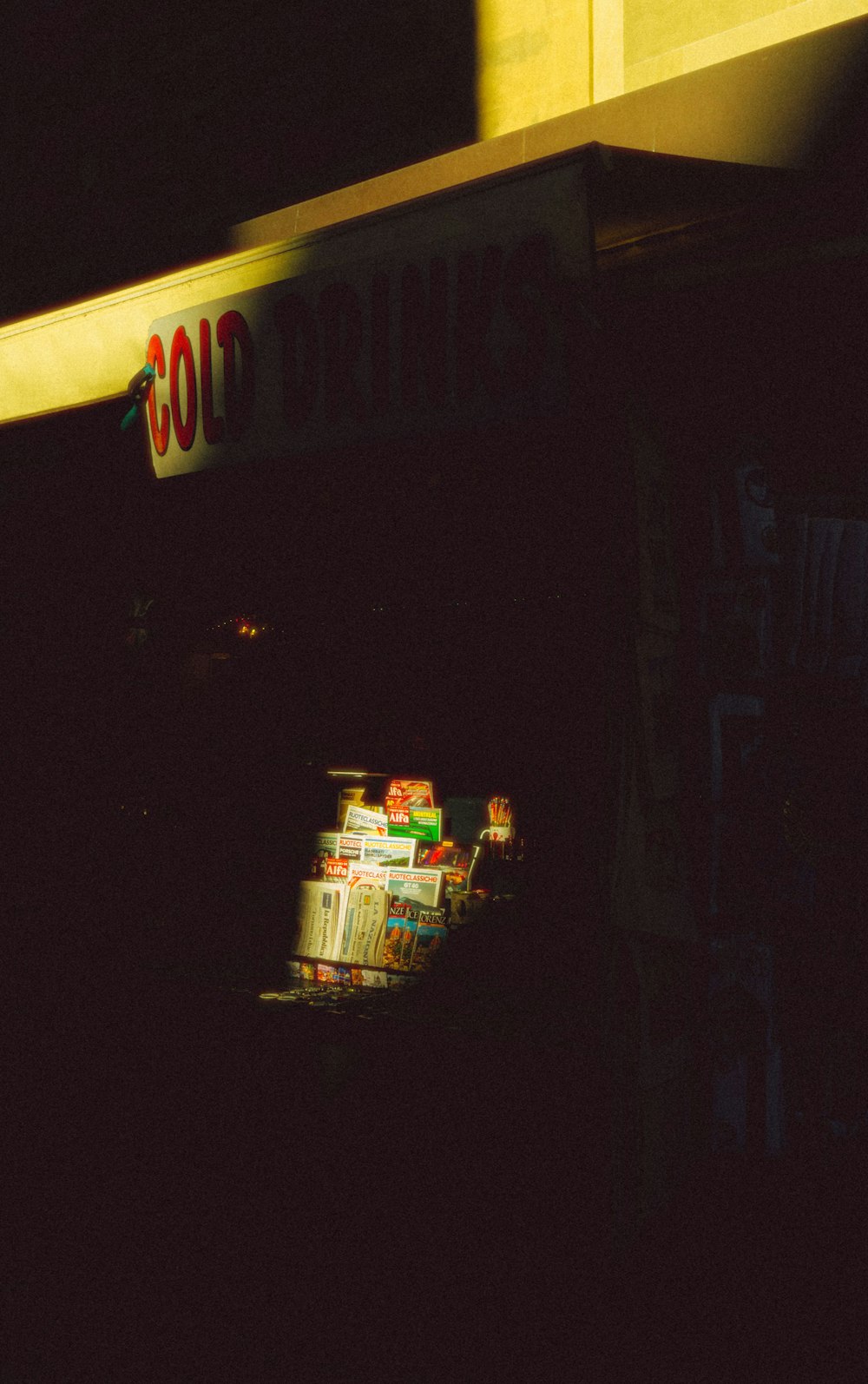 a dark picture of a store front with a light shining on it