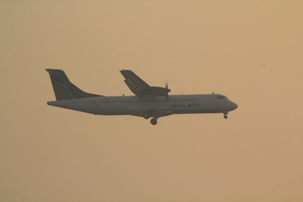 a large passenger jet flying through a hazy sky