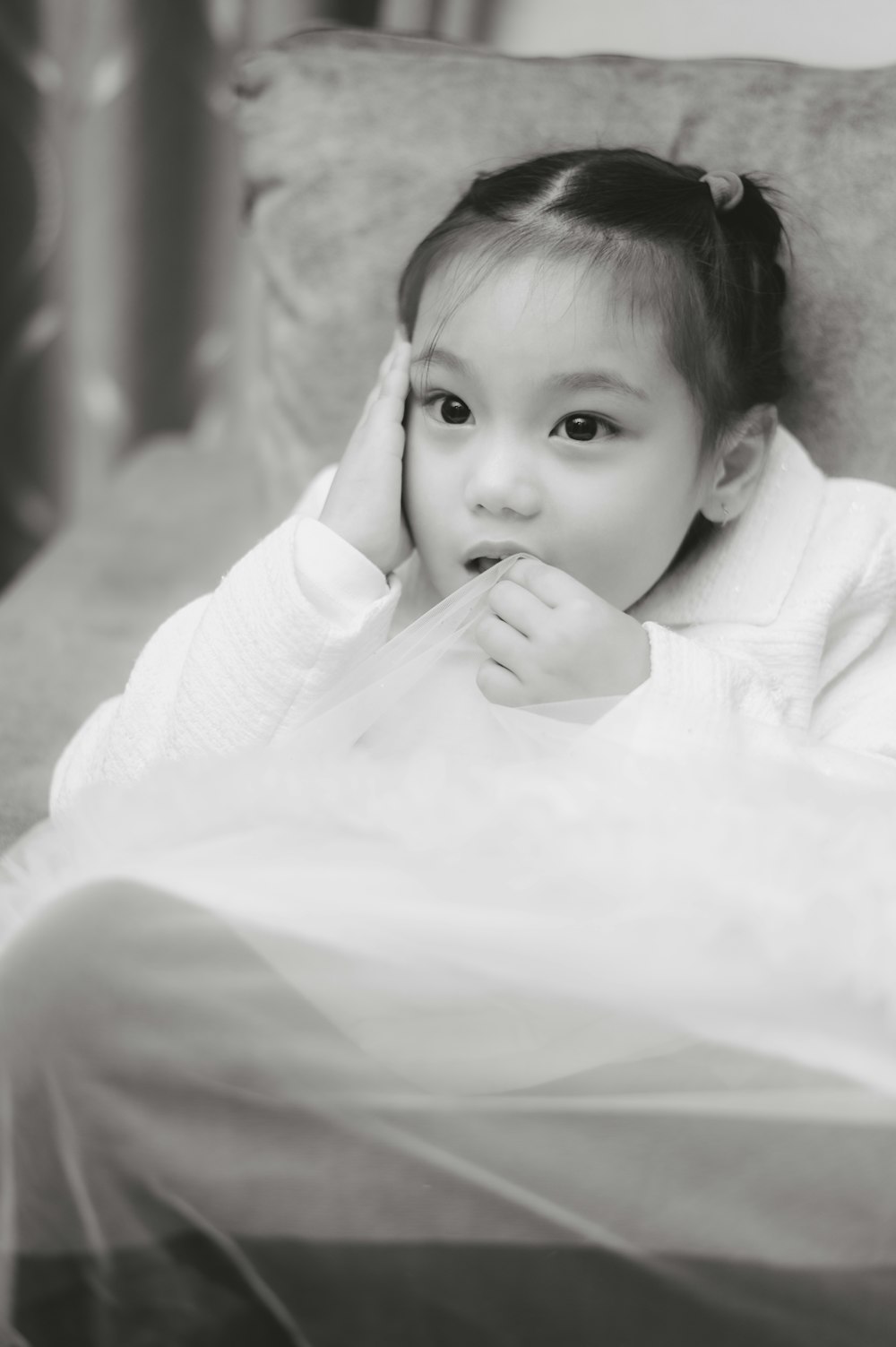 a little girl laying on top of a couch